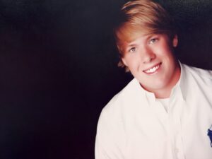 Smiling person in white shirt portrait.