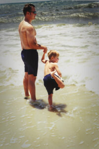 Man and child playing at the beach.