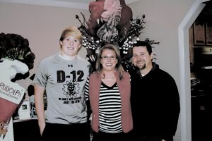 Three people posing in a decorated room.