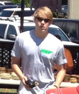 Man outdoors wearing sunglasses and a t-shirt.