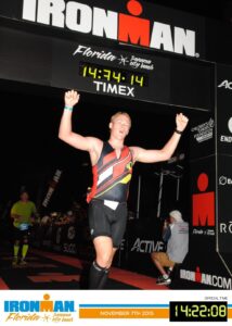 Athlete finishing Ironman Florida race at night.